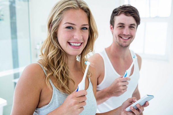 Young couple brushing their teeth at home