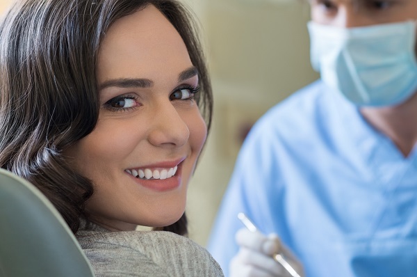 Smiling young woman receiving dental checkup every 6 months