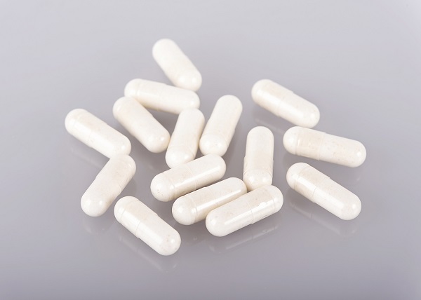 White medicine capsules on gray background