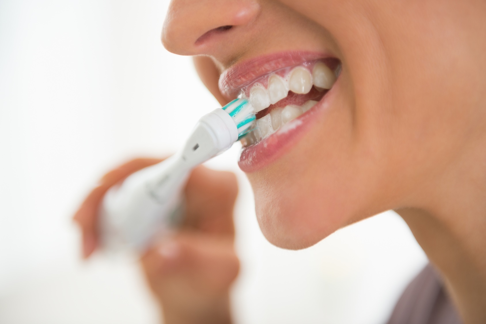 Closeup on young woman brushing teeth