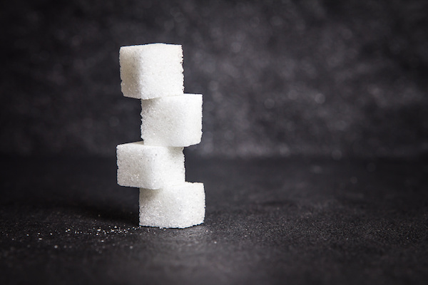 cloose up the white sugar cubes on black stone plate background