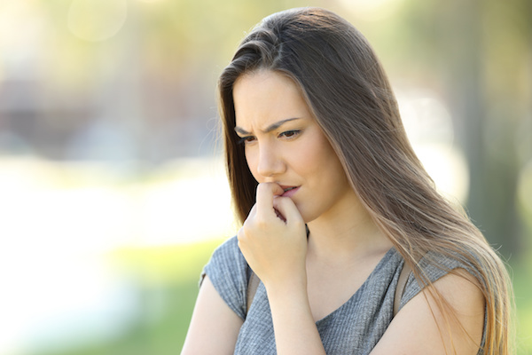 Nervous girl biting nails outside