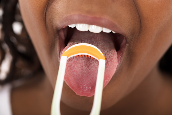 Close-up Of A Girl Cleaning Her Tongue With Scraper