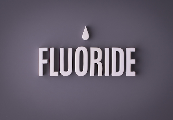 Fluoride lettering sign made with colorful background and white ceramic letters.