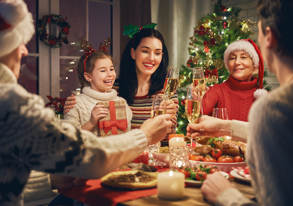 Merry Christmas! Happy family are having dinner at home. Celebration holiday and togetherness near tree.