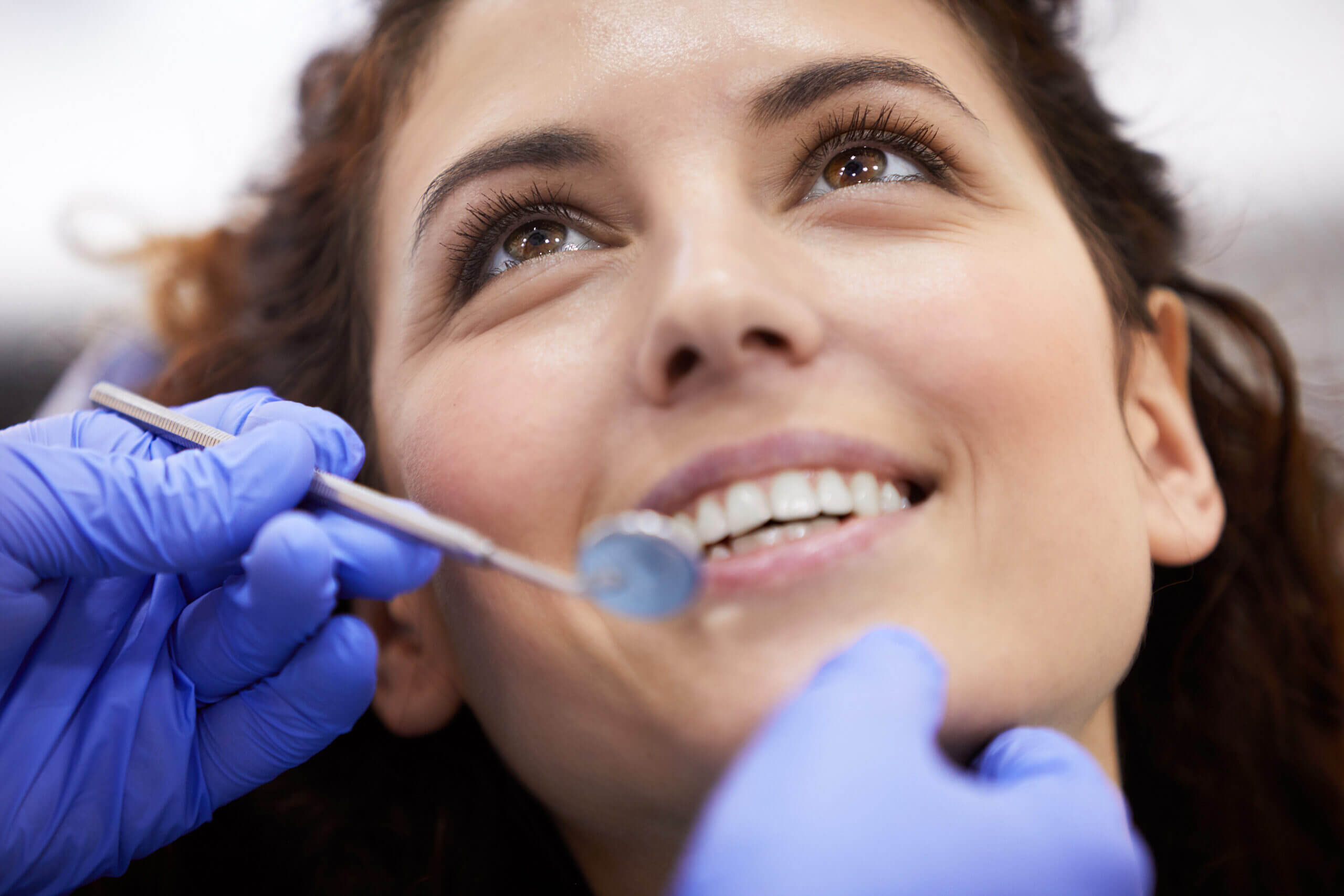 dental sealants Closeup portrait of beautiful young woman lying in dental chair and smiling during consultation, copy space