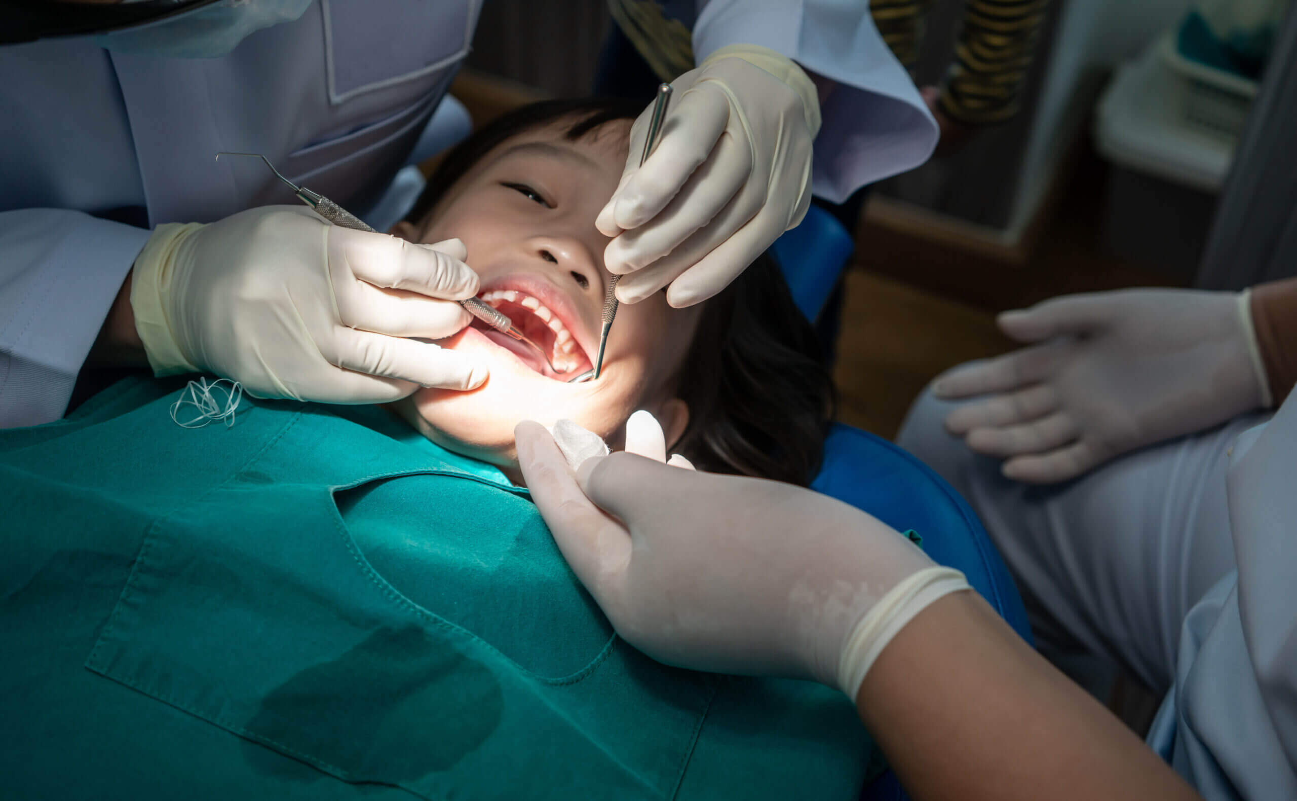 dental sealants Asian girl met the dentist for routine dental checkup and consultant. Dental cleaning process.